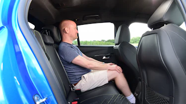 Peugeot E-208 - rear seats being sat in by Auto Express chief reviewer Alex Ingram