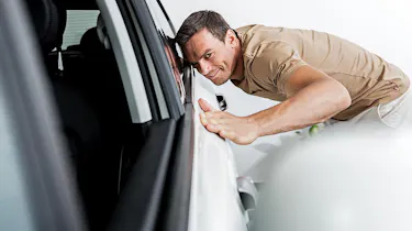 Person inspecting a car's bodywork