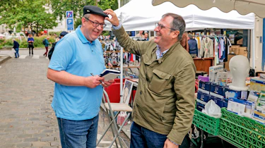 Dacia CEO Denis Le Vot fitting a hat on John McIlroy's head