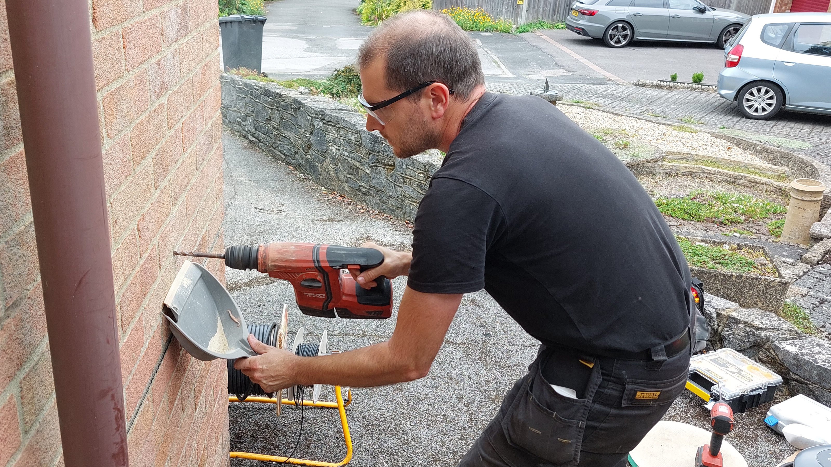 Pod Point technician drilling holes into a wall