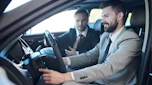 Salesperson demonstrating car to customer