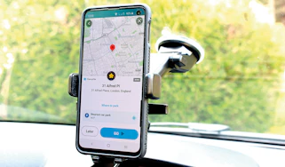 Mobile phone in windscreen-mounted holder