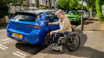 Wheelchair user plugging a charging cable into a Vauxhall Astra Electric