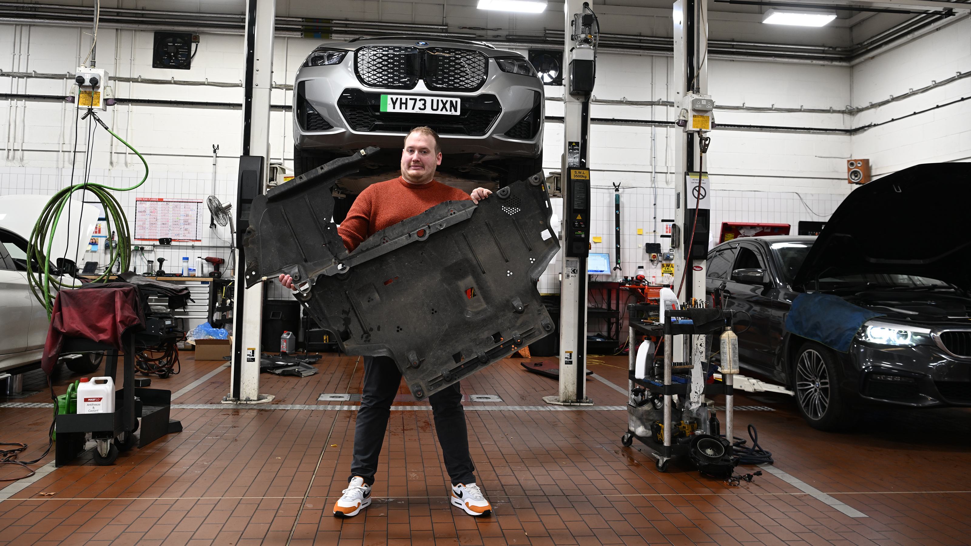 Auto Express news reporter Ellis Hyde standing in a BMW workshop