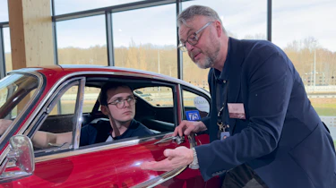 Auto Express consumer reporter Tom Jervis sitting in a Volvo P1800