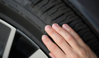 Person inspecting a tyre's condition