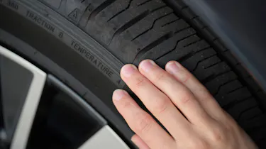 Person inspecting a tyre's condition