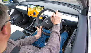 Auto Express editor Paul Barker playing video games in a Tesla