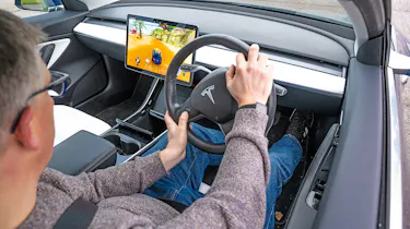 Auto Express editor Paul Barker playing video games in a Tesla