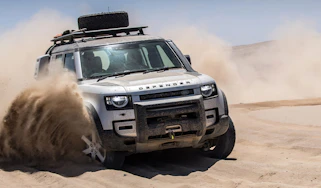 Land Rover Defender driving through sand