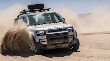 Land Rover Defender driving through sand