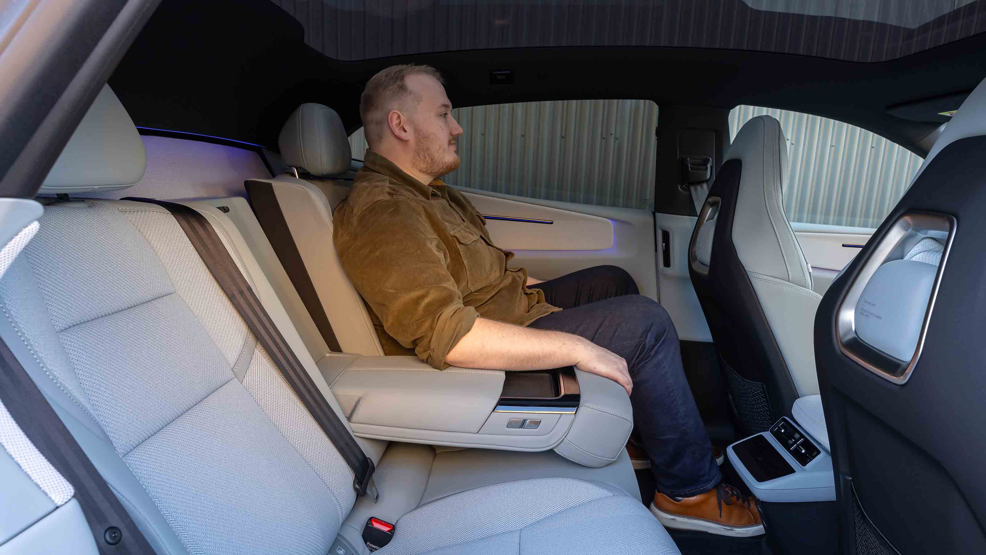 Polestar 4 Coupe - News reporter Ellis Hyde sitting in the rear seats, arm rest down