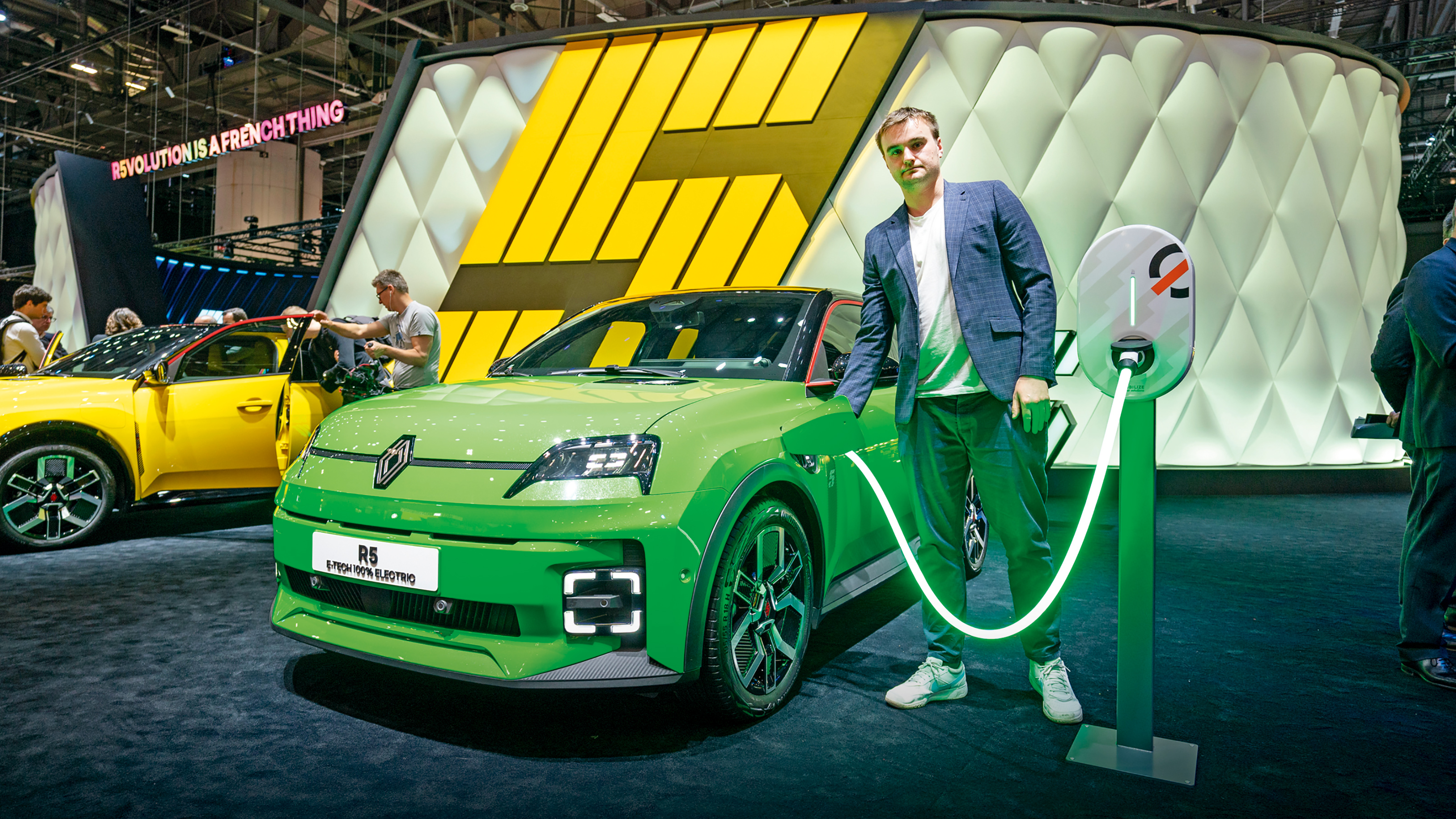 Auto Express senior news reporter Alastair Crooks holding a Renault 5's charging cable