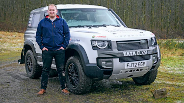 Auto Express news reporter Ellis Hyde standing next to a land Rover Defender