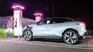 Auto Express editor Paul Barker standing next to a Renault Megane E-Tech and a set of Ionity chargepoints