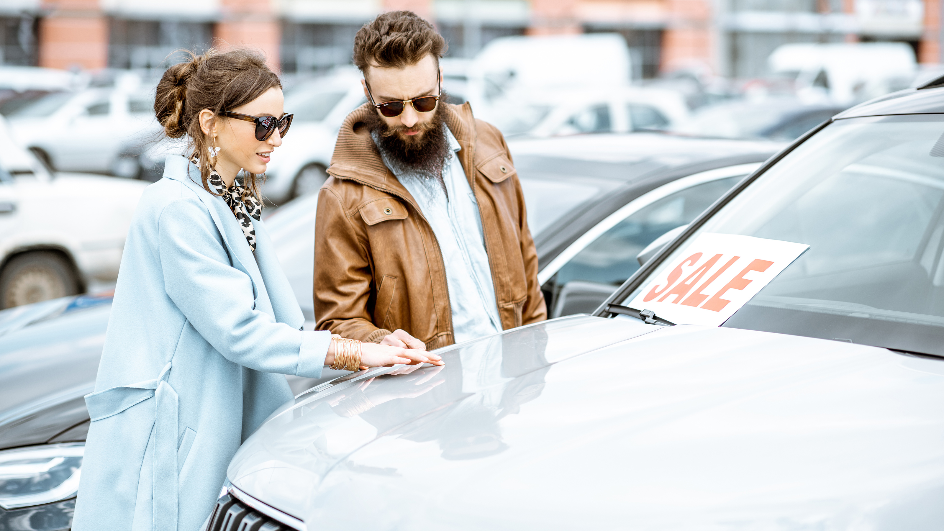 Two people inspecting a car