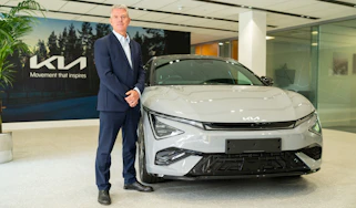 Kia's UK boss, Paul Philpott standing next to a Kia EV6