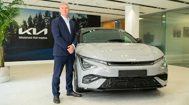 Kia's UK boss, Paul Philpott standing next to a Kia EV6
