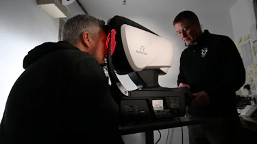 Auto Express consumer editor Chris Rosamond looking into an eye-testing machine