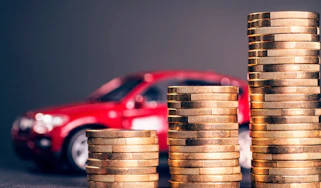 Pile of coins in front of a toy car