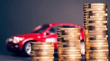 Pile of coins in front of a toy car