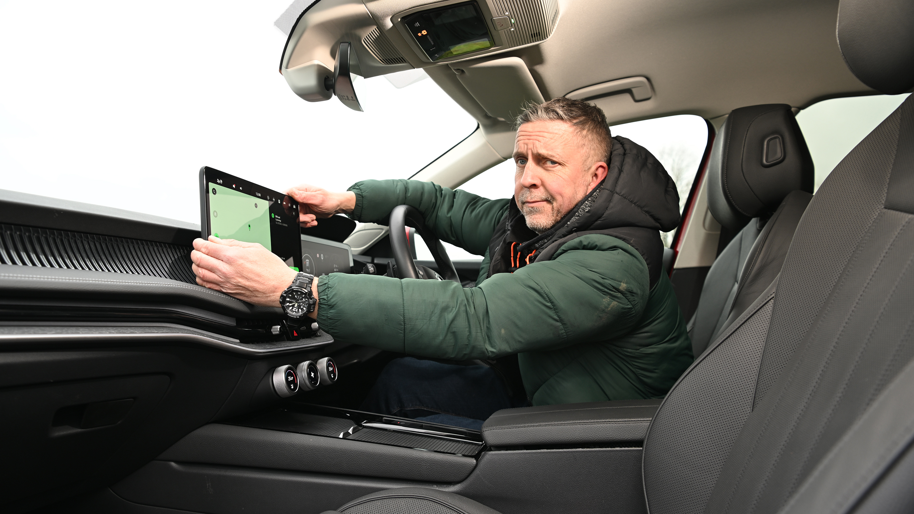 Auto Express senior photographer Pete Gibson holding the Skoda Superb's infotainment screen