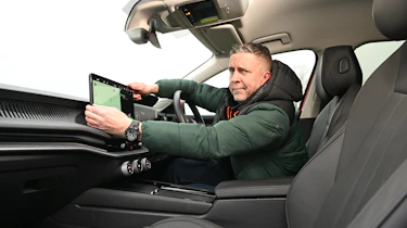 Auto Express senior photographer Pete Gibson holding the Skoda Superb's infotainment screen
