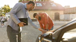 Two people inspecting a used car