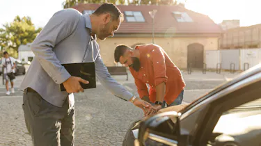 Two people inspecting a used car