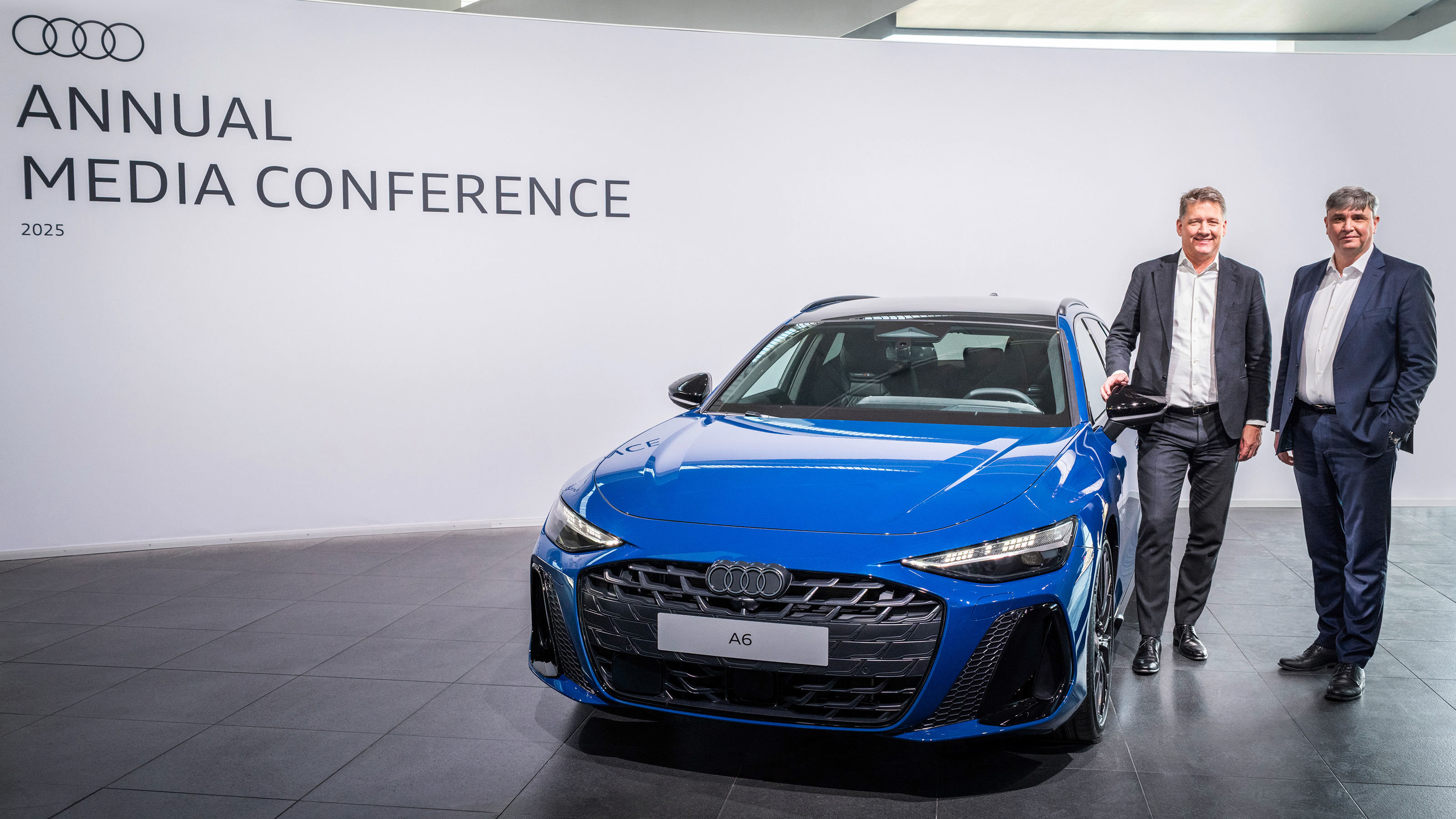 Audi executives standing next to an Audi A6 Avant