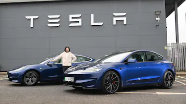 Auto Express senior staff writer Jordan Katsianis standing between two Tesla Model 3s