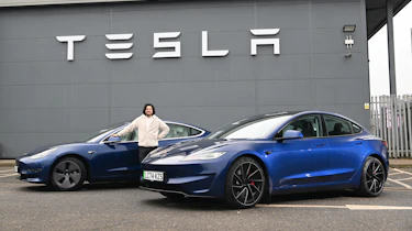 Auto Express senior staff writer Jordan Katsianis standing between two Tesla Model 3s