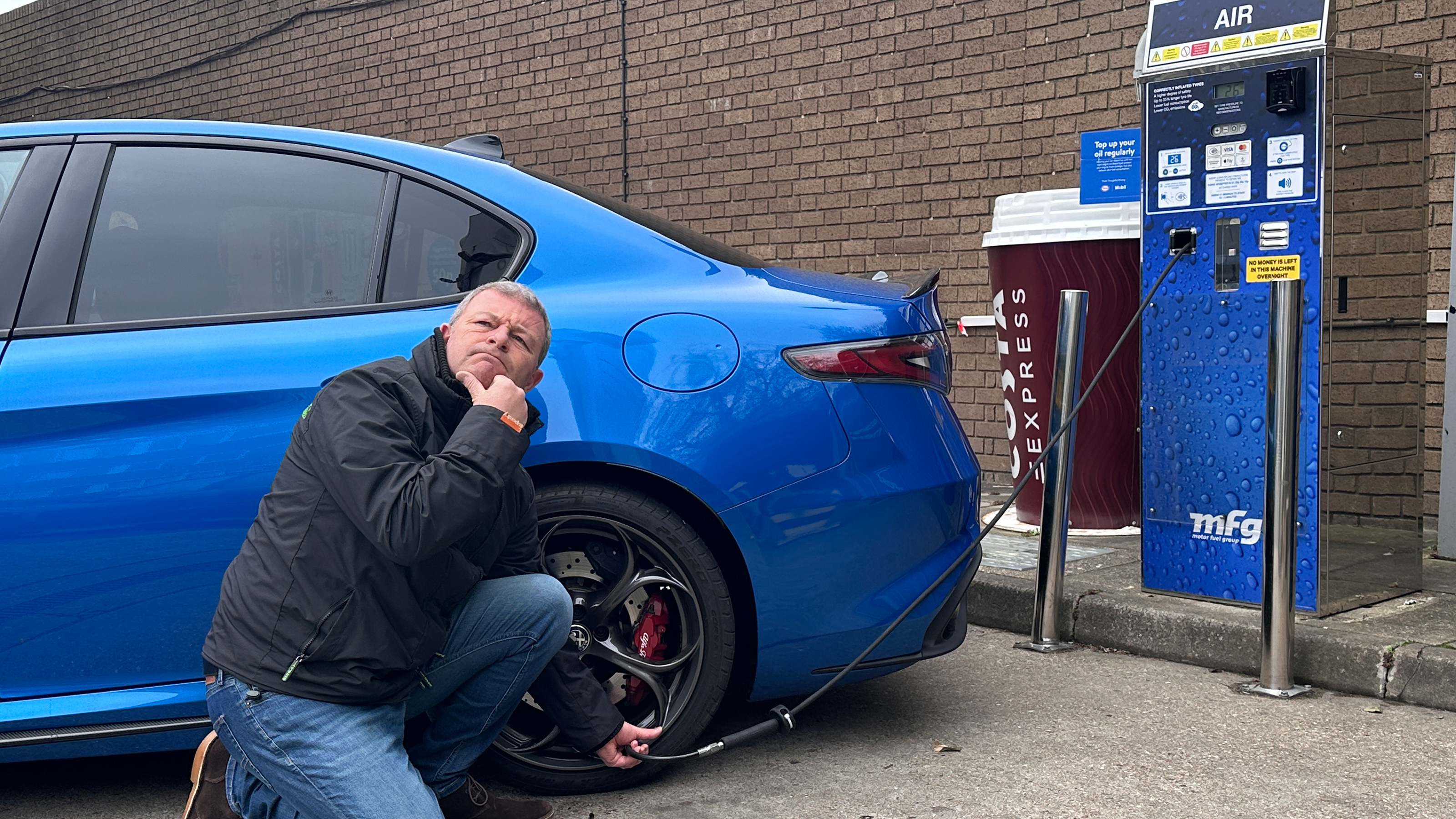 Auto Express contributor Steve Stucliffe pumping up the Alfa Romeo Giulia Quadrifoglio's rear nearside tyre
