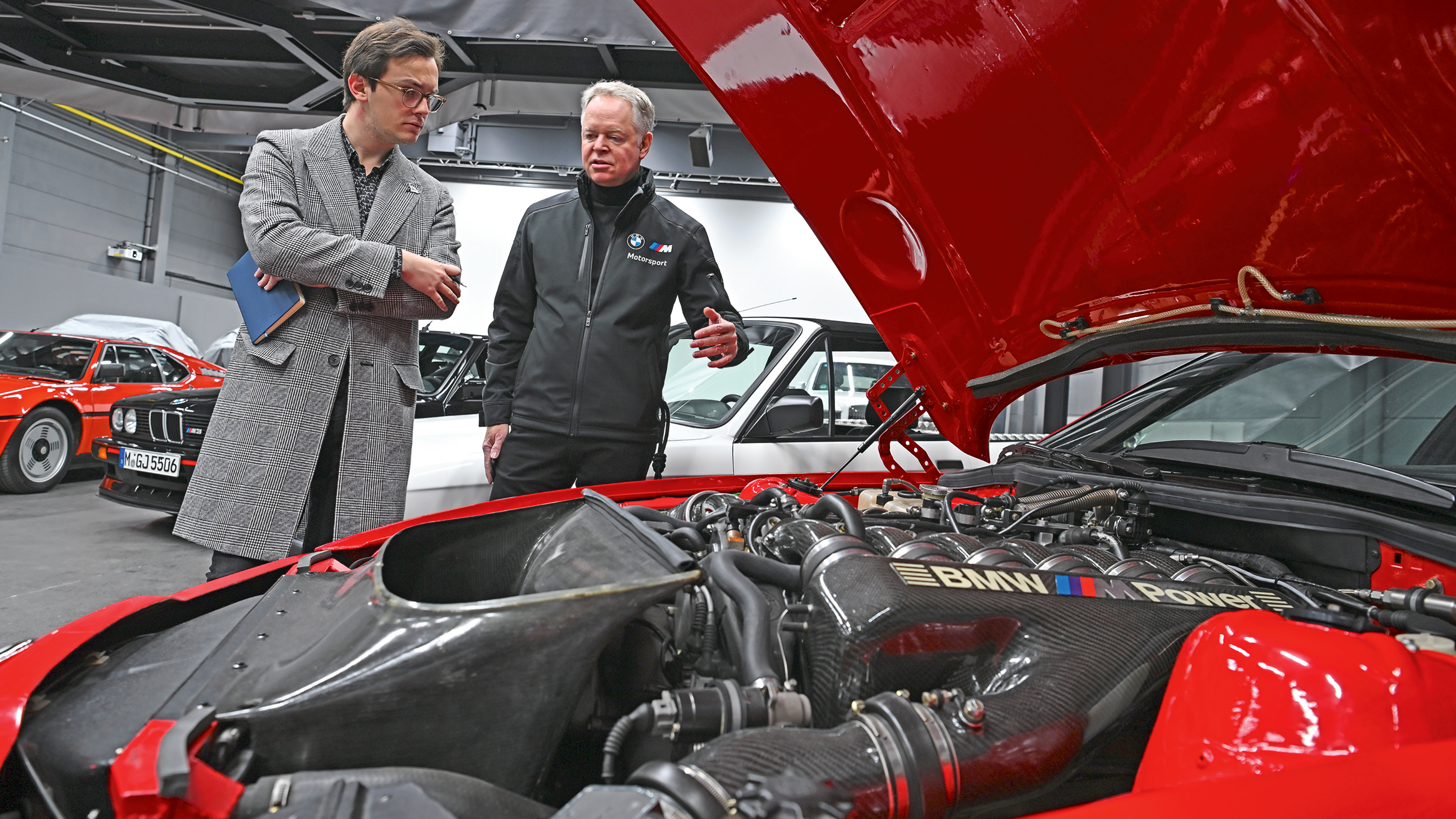 Auto Express consumer reporter Tom Jervis inspecting a BMW M1's engine bay