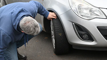Auto Express consumer editor Chris Rosamond inspecting a Vauxhall Corsa's tyre