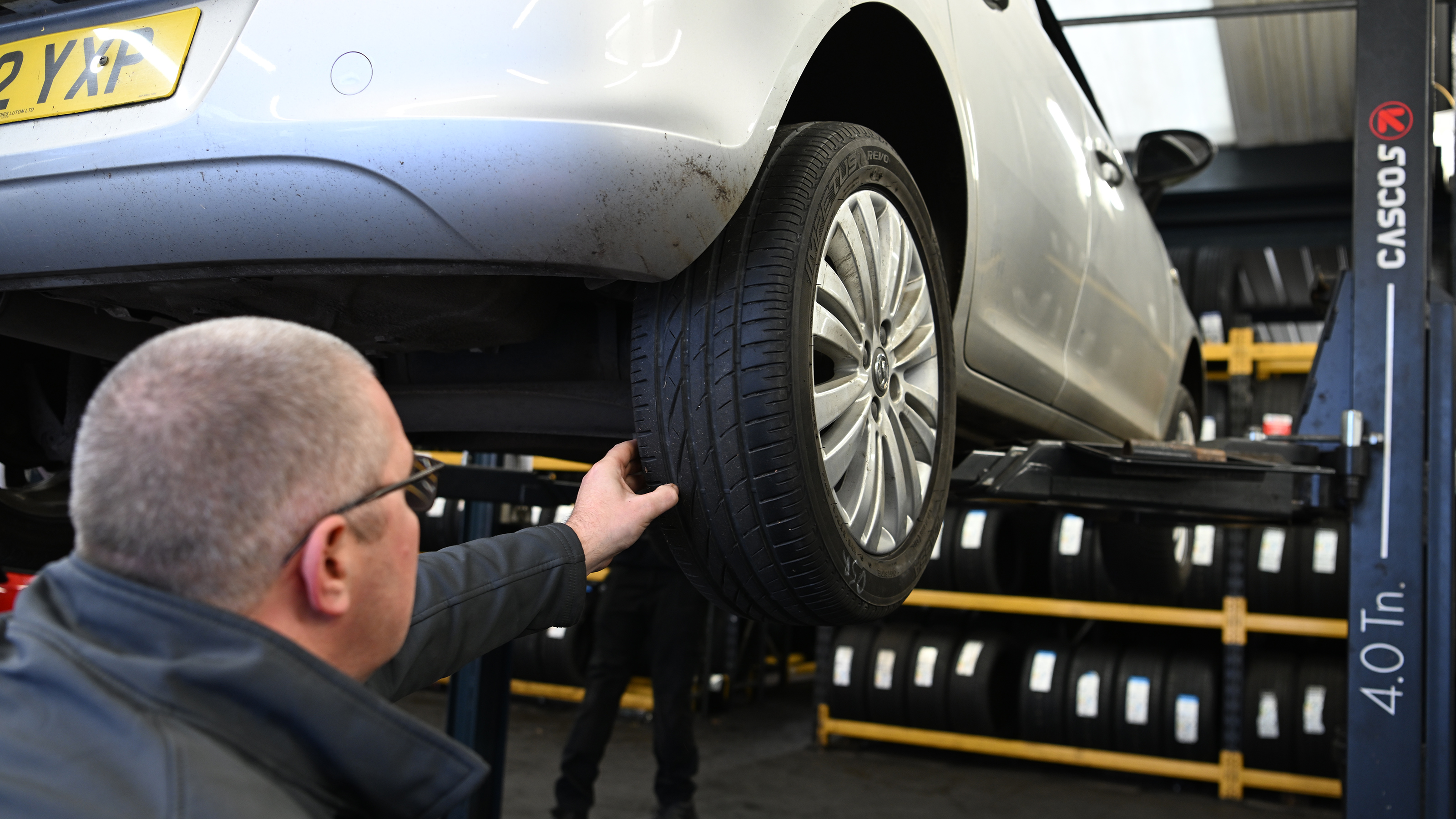 Protyre area manager Simon Hall inspecting a Vauxhall Corsa's tyre