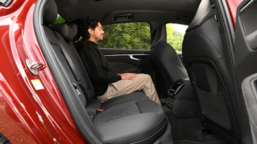 Auto Express senior news editor Jordan Katsianis sitting in the Audi A6 e-Hybrid's back seat