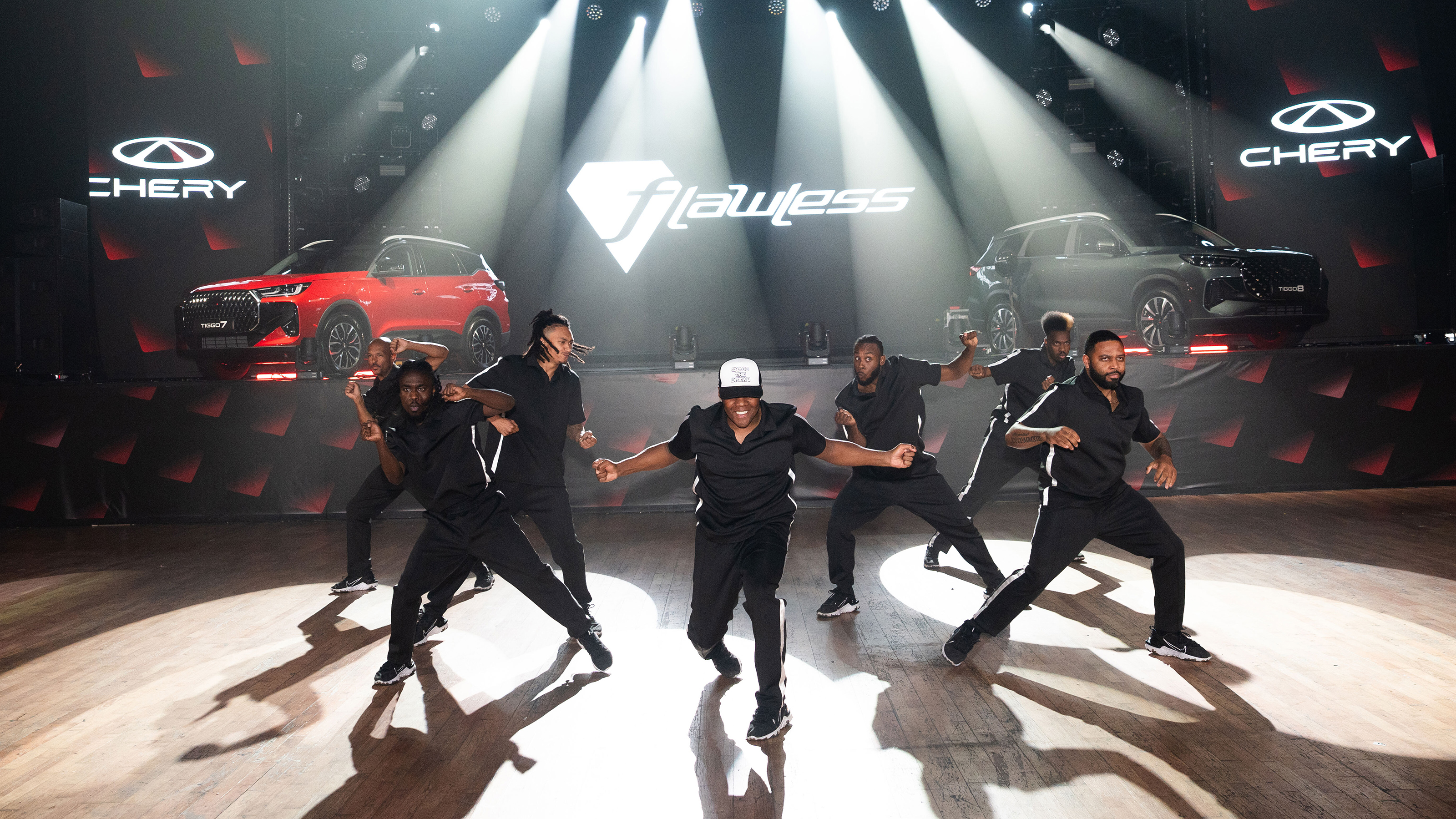 Dancers posing in front of two Chery SUVs