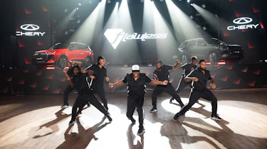 Dancers posing in front of two Chery SUVs