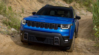 New Jeep Cherokee - blue front climbing up a dirt track