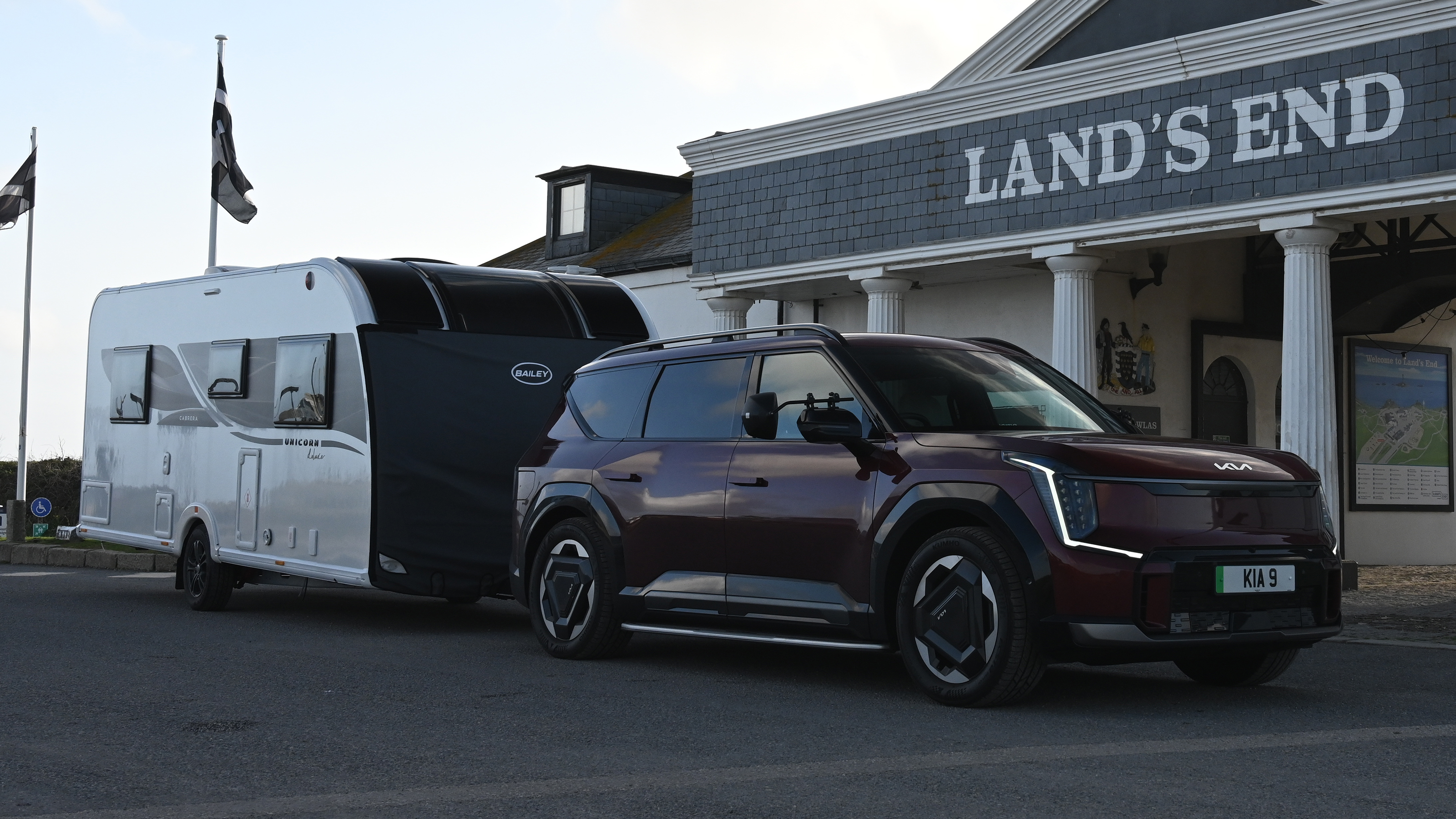 EV tow test - Kia and caravan in front of Lands End hotel