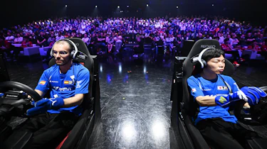 Sim racers competing in front of a crowd