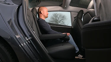 Auto Express chief reviewer Alex Ingram sitting in the Tesla Model 3's back seat