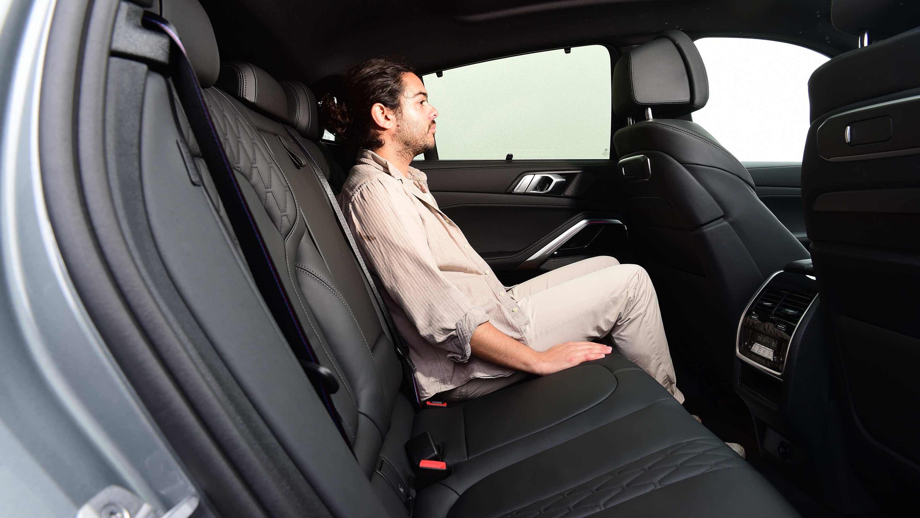 Auto Express senior staff writer Jordan Katsianis sitting in the BMW X6 xDrive40i's back seat