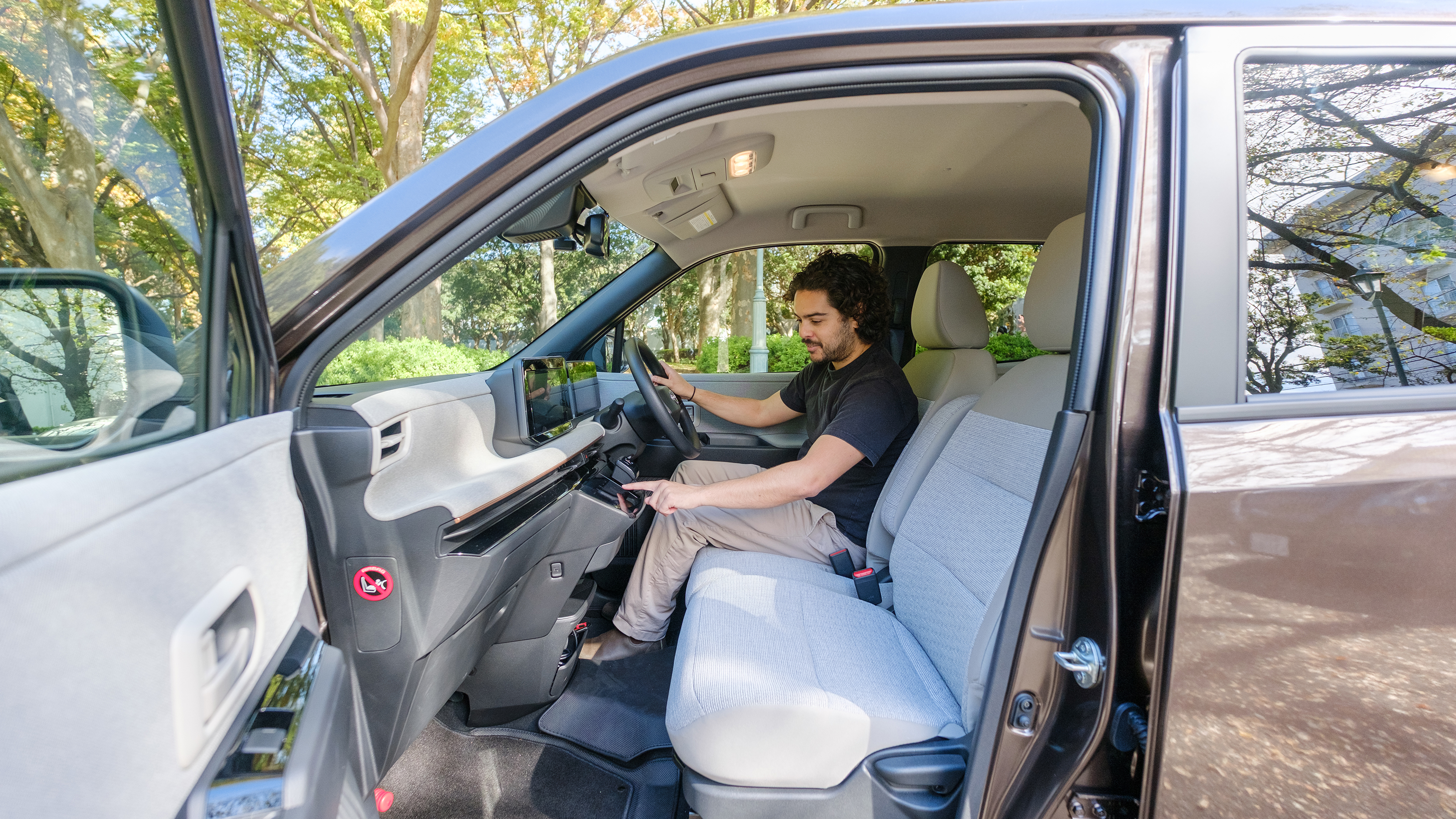 Nissan Sakura - front interior, with Auto Express senior staff writer Jordan Katsianis sitting in the drivers seats