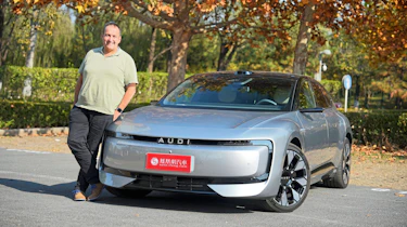 Thomas Geiger standing next to the AUDI E5 Sportback