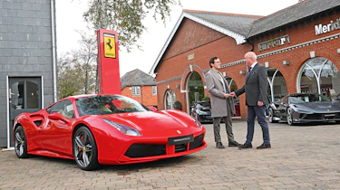 How to buy a used supercar - shaking hands in front of dealership