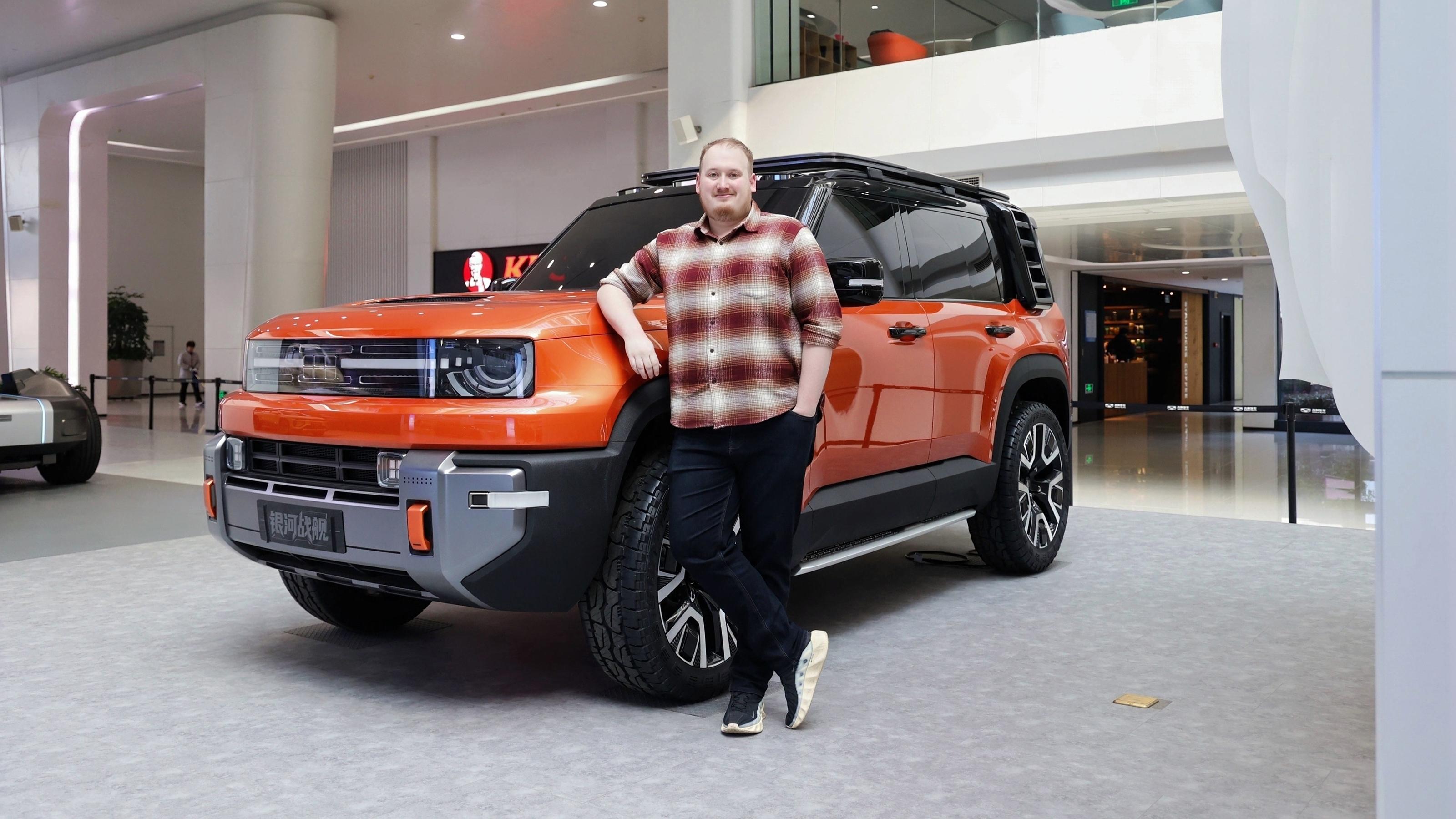 Auto Express news reporter Ellis Hyde standing in front of the Geely Galaxy Cruiser