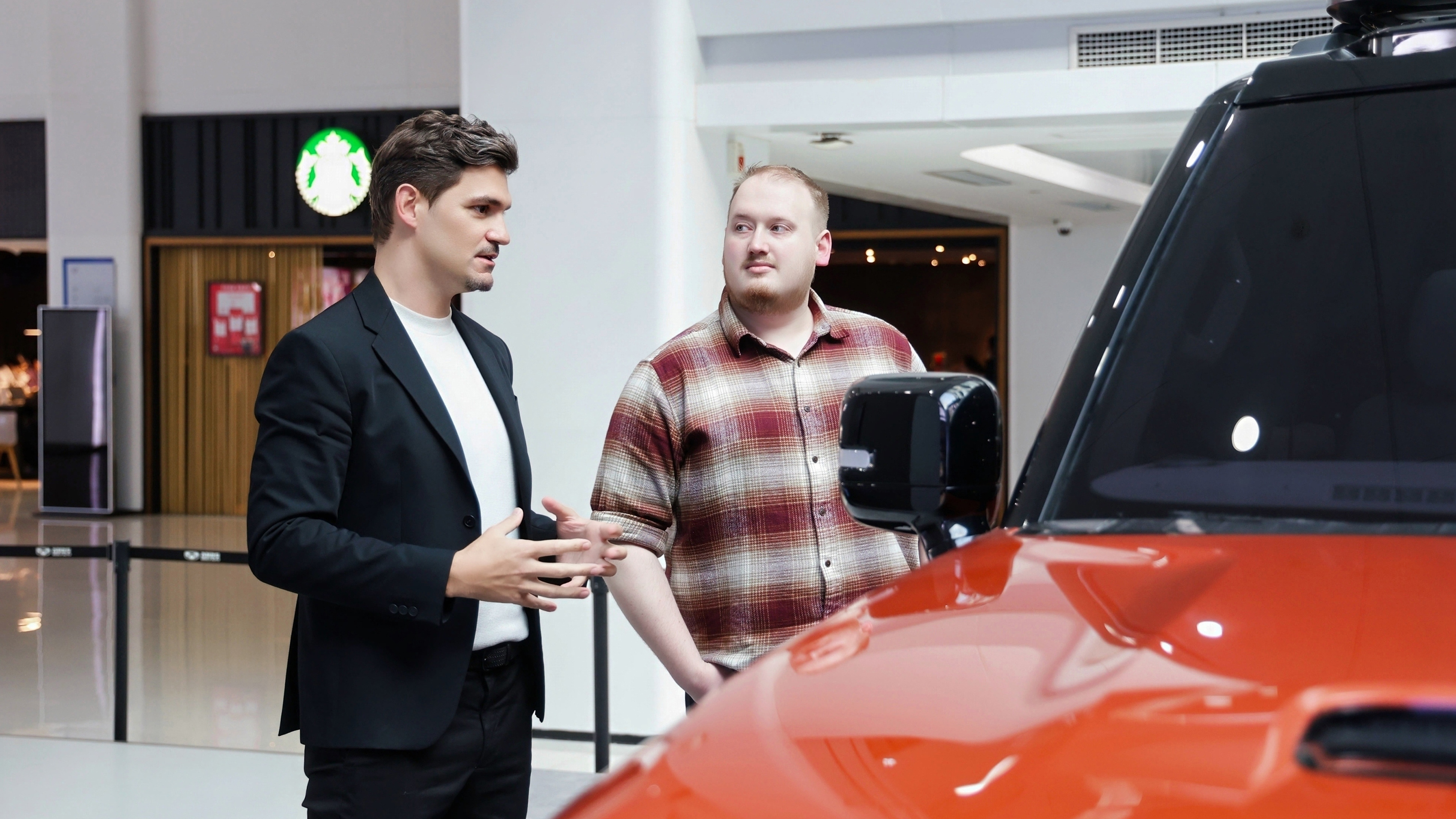 Auto Express news reporter Ellis Hyde and Flavien Dachet talking while standing by the Geely Galaxy Cruiser