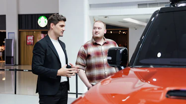Auto Express news reporter Ellis Hyde and Flavien Dachet talking while standing by the Geely Galaxy Cruiser